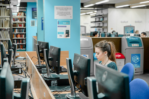 A student in a computer room working on a computer screen